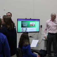 people standing around a senior project on a tv